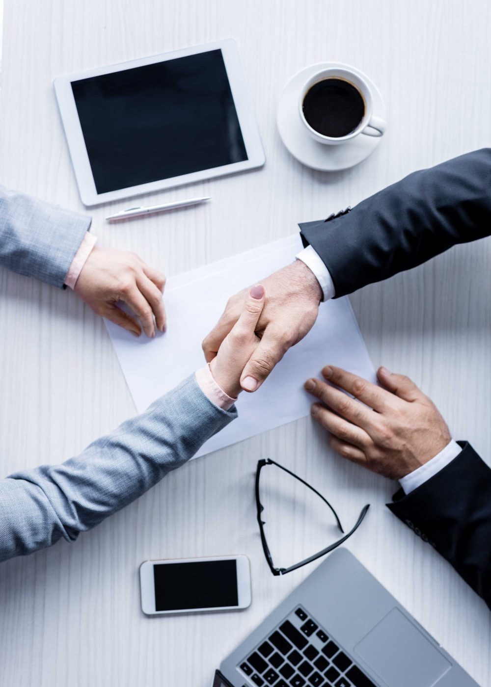 top view of business people shaking hands during meeting